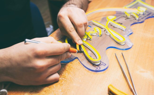 The worker is production the sign made from the led neon ribbon
